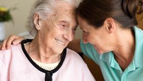 Elderly woman smiling with caretaker