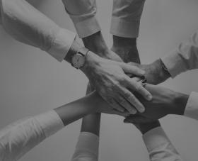 black and white photo of diverse hands coming together 